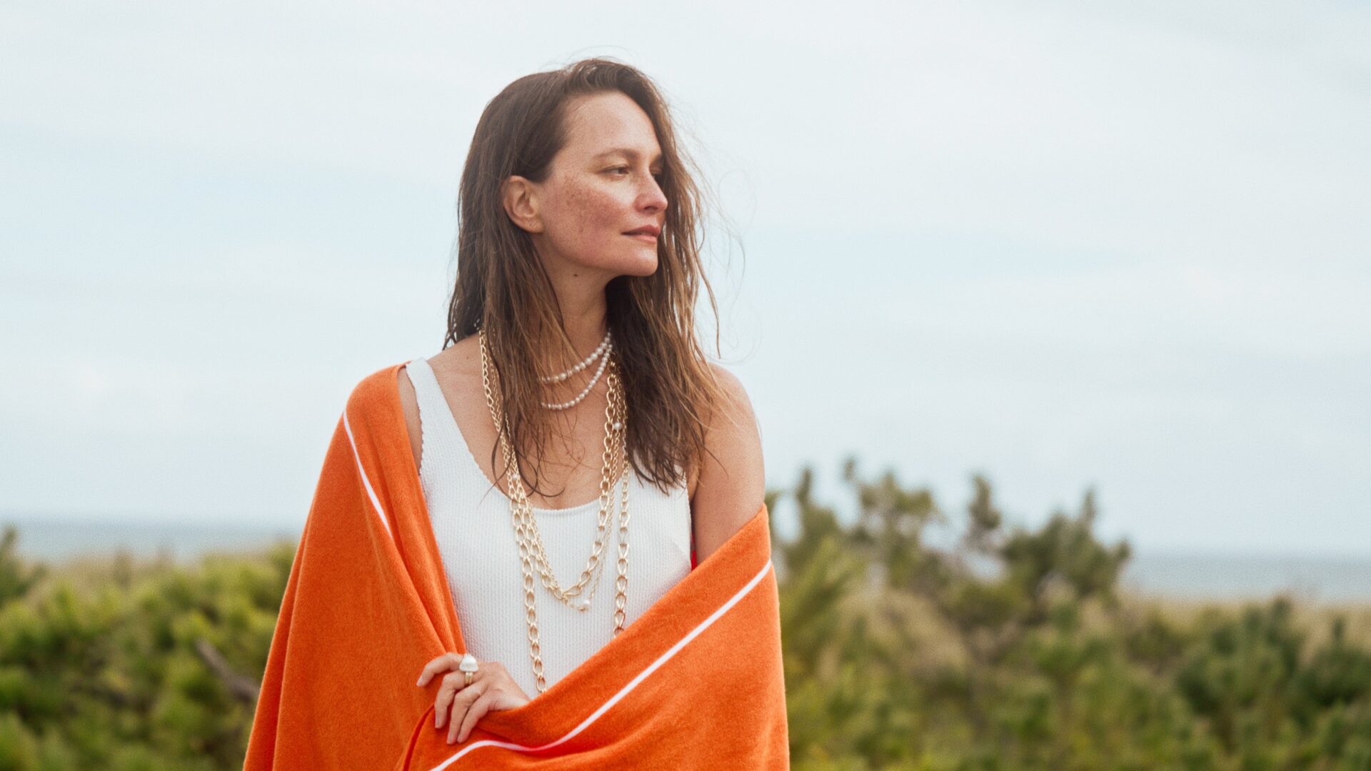 Pania Rose embodies the essence of summer, adorned in John Hardy’s handcrafted jewelry, set against the serene backdrop of the coastline.