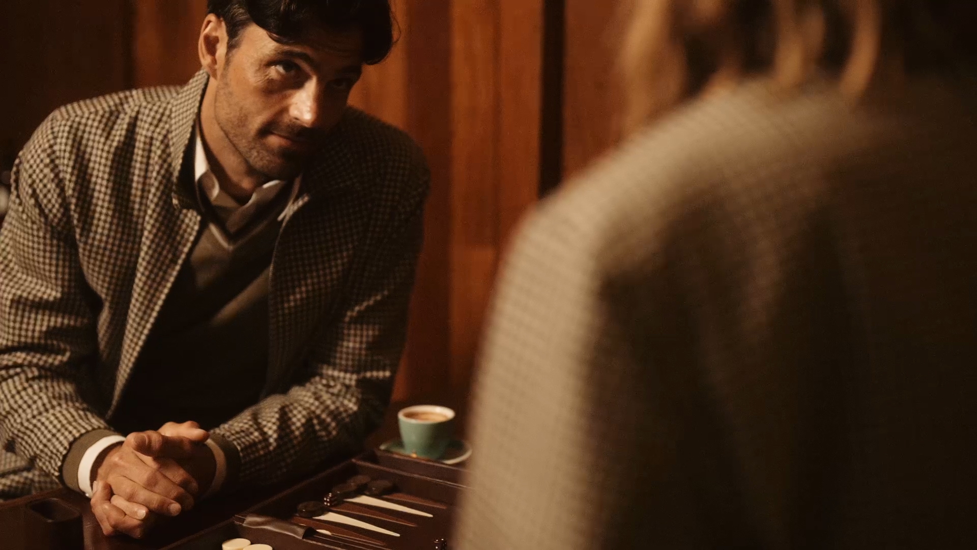 Peter Badenhop in a houndstooth jacket leaning across a table at Frenchette NYC, Madison Moehling blurred in the foreground, for the Todd Snyder American Form Fall campaign.